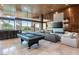 Open living room featuring a sleek pool table, bar area, and floor-to-ceiling windows at 8 Meadowhawk Ln, Las Vegas, NV 89135