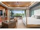 A bed faces sliding glass doors to a patio in a large bedroom with a ceiling fan and accent walls at 8 Meadowhawk Ln, Las Vegas, NV 89135