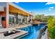 Beautiful pool with integrated spa, outdoor kitchen, and modern patio furniture at 8 Meadowhawk Ln, Las Vegas, NV 89135