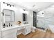 Modern bathroom with double vanities, a glass shower, and black and white marble accents at 8113 Bay Springs Dr, Las Vegas, NV 89128