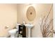 Cozy bathroom featuring a pedestal sink and decorative mirror, along with a nearby toilet at 8316 Mokena Ave, Las Vegas, NV 89178
