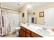 Bathroom featuring double sinks, wood cabinets, a shower with tile surround, and neutral paint at 8316 Mokena Ave, Las Vegas, NV 89178