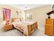 Comfortable bedroom with a wood frame bed, light colored walls, and a window at 8316 Mokena Ave, Las Vegas, NV 89178