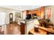 Open kitchen layout with wood cabinets, black appliances, granite counters, and hardwood flooring at 8316 Mokena Ave, Las Vegas, NV 89178