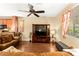 Cozy living room with a large window, ceiling fan, wood floors, and comfortable seating at 8316 Mokena Ave, Las Vegas, NV 89178