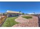 Enjoy the backyard with artificial turf, a brick walkway, and a rock landscape surrounding the yard at 842 Envoy Cir, Henderson, NV 89002