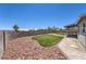 Low maintenance backyard features a mix of artificial turf, rock landscape, and a covered patio at 842 Envoy Cir, Henderson, NV 89002