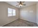 Cozy bedroom with neutral walls, carpet, ceiling fan, and a bright window at 842 Envoy Cir, Henderson, NV 89002