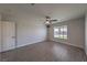Spacious bedroom with wood-look flooring, ceiling fan, and a window offering natural light at 842 Envoy Cir, Henderson, NV 89002
