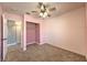 Cozy bedroom with a pink accent wall, a ceiling fan, carpet, and a closet at 842 Envoy Cir, Henderson, NV 89002