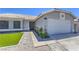 Close-up of a home featuring desert landscaping, green grass, and a two-car garage at 842 Envoy Cir, Henderson, NV 89002