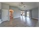 Open living room with wood-look floors, ceiling fan, and access to both kitchen and backyard at 842 Envoy Cir, Henderson, NV 89002