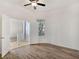 A bright bedroom featuring wood floors, a ceiling fan, and white walls with connecting rooms and hallways at 8981 Rivers Edge Dr, Las Vegas, NV 89117