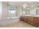 Luxurious bathroom with a jacuzzi tub, double sink vanity, and tile flooring at 9101 Alta Dr # 203, Las Vegas, NV 89145