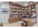 Home office with custom built-in wood bookshelves and an executive desk at 9101 Alta Dr # 203, Las Vegas, NV 89145