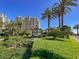 Landscaped entrance to Queensridge Place featuring signage and mature palm trees at 9101 Alta Dr # 203, Las Vegas, NV 89145