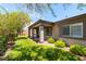 View of the landscaped backyard featuring lush grass, mature trees, and a covered patio at 913 Hickory Park St, Las Vegas, NV 89138