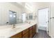Bathroom with double sinks, wood cabinets, and tile floors at 913 Hickory Park St, Las Vegas, NV 89138