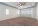 Large main bedroom featuring a ceiling fan, tray ceiling, and many windows at 913 Hickory Park St, Las Vegas, NV 89138