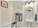 Neat half-bathroom featuring a pedestal sink and decorative wall art at 10001 Blairwood Ct, Las Vegas, NV 89178