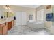 Bright bathroom with a soaking tub, double vanity, and stylish tile flooring at 10001 Blairwood Ct, Las Vegas, NV 89178
