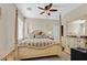 Spacious bedroom with a four-poster bed, ceiling fan, carpet, and an ensuite bathroom at 10001 Blairwood Ct, Las Vegas, NV 89178