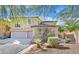 Inviting two-story home with a three-car garage, well-manicured lawn, and lush landscaping at 10001 Blairwood Ct, Las Vegas, NV 89178