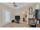 Cozy living room with a TV, closet with shuttered doors, and an ensuite bathroom view at 10001 Blairwood Ct, Las Vegas, NV 89178