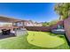 This backyard features an outdoor kitchen, a covered patio and a putting green at 1008 Welkin St, Henderson, NV 89052