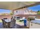 This covered patio includes a dining area, a hot tub, a lounge chair and an outdoor kitchen at 1008 Welkin St, Henderson, NV 89052