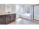 Bright bathroom featuring a modern vanity, a soaking tub under a window, and a sleek glass-enclosed shower at 10184 Juniper Valley St, Las Vegas, NV 89166