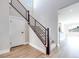 Bright entryway showcases the staircase with wood trim and modern metal railing at 10184 Juniper Valley St, Las Vegas, NV 89166