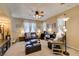 Cozy living room featuring a ceiling fan, plush seating, and natural light from curtained windows at 10583 Mann St, Las Vegas, NV 89141