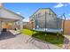 Beautiful backyard with pavers, artificial grass, covered patio, and trampoline for enjoyment at 1075 Page Park Ln, Henderson, NV 89011