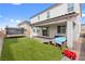 Landscaped backyard with pavers, turf, covered patio, and trampoline for active play at 1075 Page Park Ln, Henderson, NV 89011