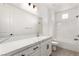 Stylish bathroom with double vanity, a large mirror, and white subway tile in shower at 1075 Page Park Ln, Henderson, NV 89011