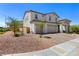 Charming two-story home with brick driveway and a three-car garage in a desert landscape at 1075 Page Park Ln, Henderson, NV 89011