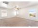 Expansive bedroom with neutral carpet, bright windows, and a ceiling fan, offering comfort and style at 11749 Villa San Michele Ct, Las Vegas, NV 89138