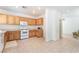Well-lit kitchen with wooden cabinets, white appliances, and tile flooring, providing a clean and functional space at 11749 Villa San Michele Ct, Las Vegas, NV 89138