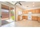Functional kitchen with wood cabinets, white appliances, and a sliding glass door leading to the backyard at 11749 Villa San Michele Ct, Las Vegas, NV 89138