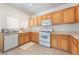 Practical kitchen featuring wood cabinets, essential appliances, and neutral countertops, offering a blank canvas at 11749 Villa San Michele Ct, Las Vegas, NV 89138