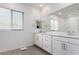 Bright bathroom featuring a double vanity, framed mirror, and neutral tile flooring at 12332 Switchgrass Ave, Las Vegas, NV 89138