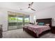 Bedroom featuring a ceiling fan, large bed and sliding glass doors to a balcony at 12332 Switchgrass Ave, Las Vegas, NV 89138