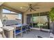 Covered patio with ceiling fan, dining table with seating and view to backyard at 12332 Switchgrass Ave, Las Vegas, NV 89138