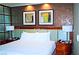 This bedroom features a bed, nightstands with lamps, and light brown accent wall with two paintings at 125 E Harmon Ave # 1918, Las Vegas, NV 89109