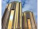 Low angle view of two luxury high-rise condo buildings with gold-tinted windows against a cloudy sky at 125 E Harmon Ave # 1918, Las Vegas, NV 89109