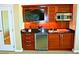 This kitchenette features wood cabinetry, stainless steel appliances, and black countertops at 125 E Harmon Ave # 1918, Las Vegas, NV 89109