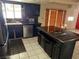 Large kitchen with tile flooring and black cabinets and an island, enhanced by natural lighting at 1674 Seneca Ln, Las Vegas, NV 89169