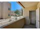 Cozy balcony overlooking landscaped common area in a multi-unit residential building under a sunny, blue sky at 1846 N Decatur Blvd # 104, Las Vegas, NV 89108