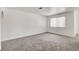 Bright living area with neutral carpeting, a large window, and freshly painted white walls at 1846 N Decatur Blvd # 104, Las Vegas, NV 89108
